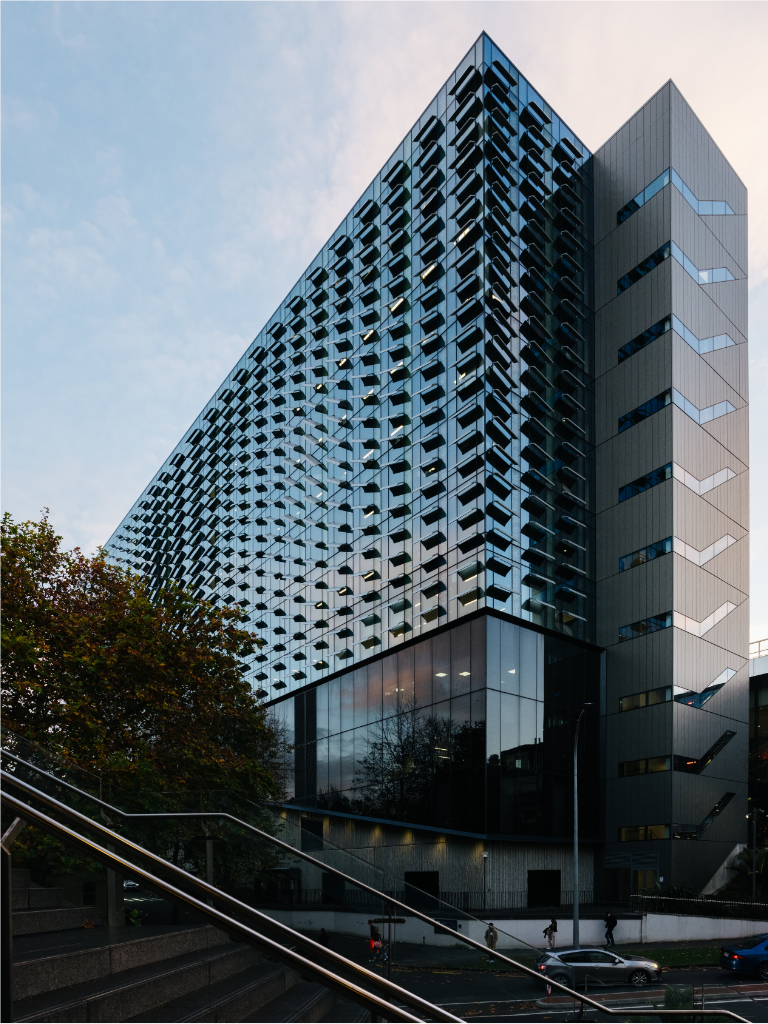 A tall university building clad in mirrored glass