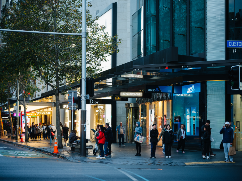 People waiting to cross the road at a Queen Street intersection