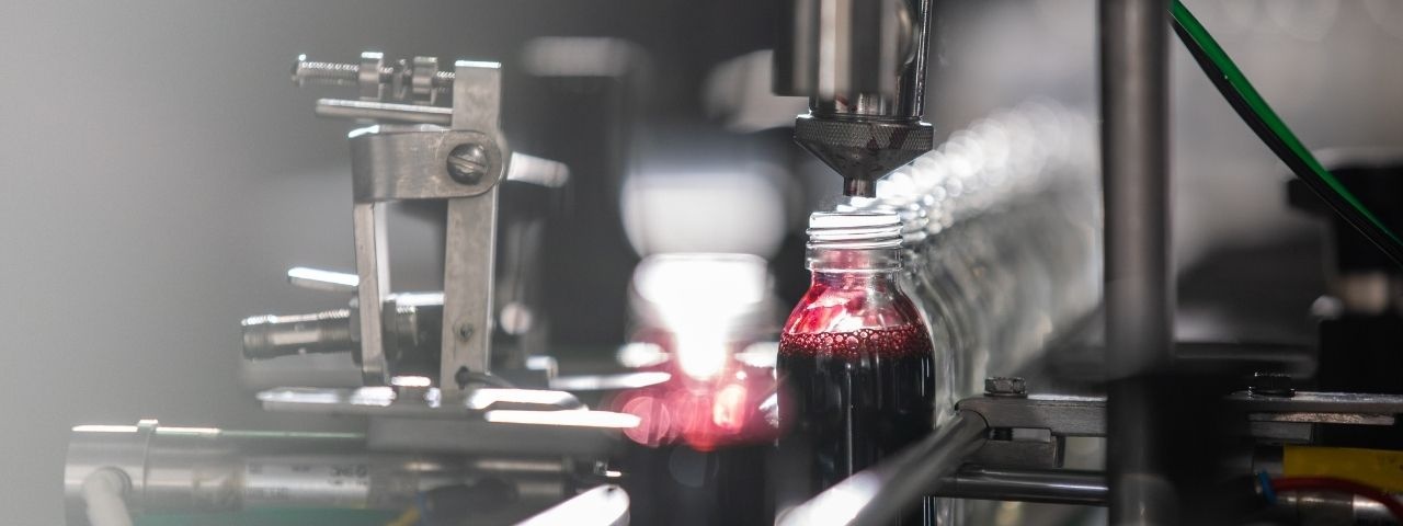 Bottle being filled on conveyor belt